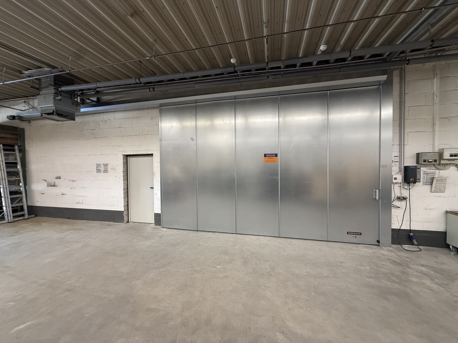 Hörmann Brandschutzschiebetor mit separater Brandschutztür in einer Industriehalle